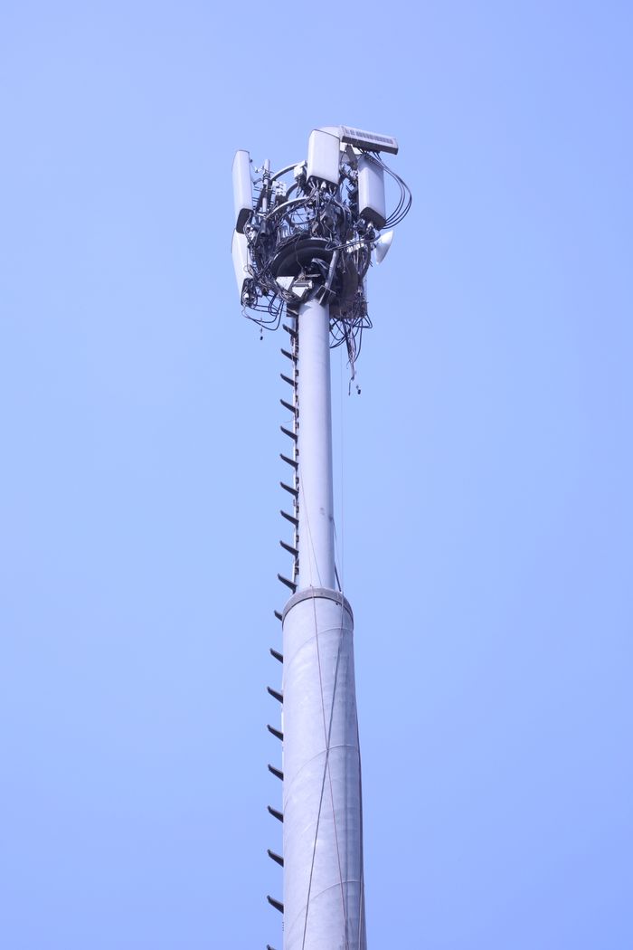 A tall communication tower reaching up into a clear blue sky, showcasing modern technology.